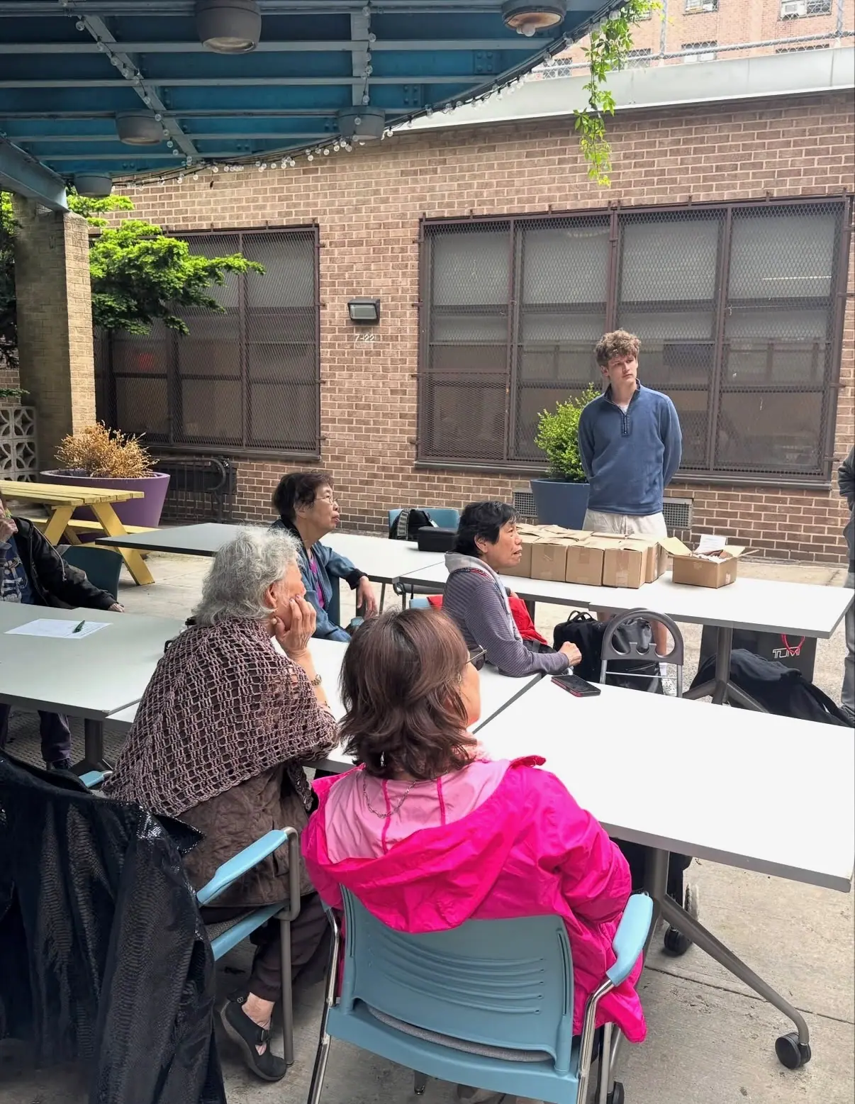 Residents opening their boxes together at the courtyard tables.