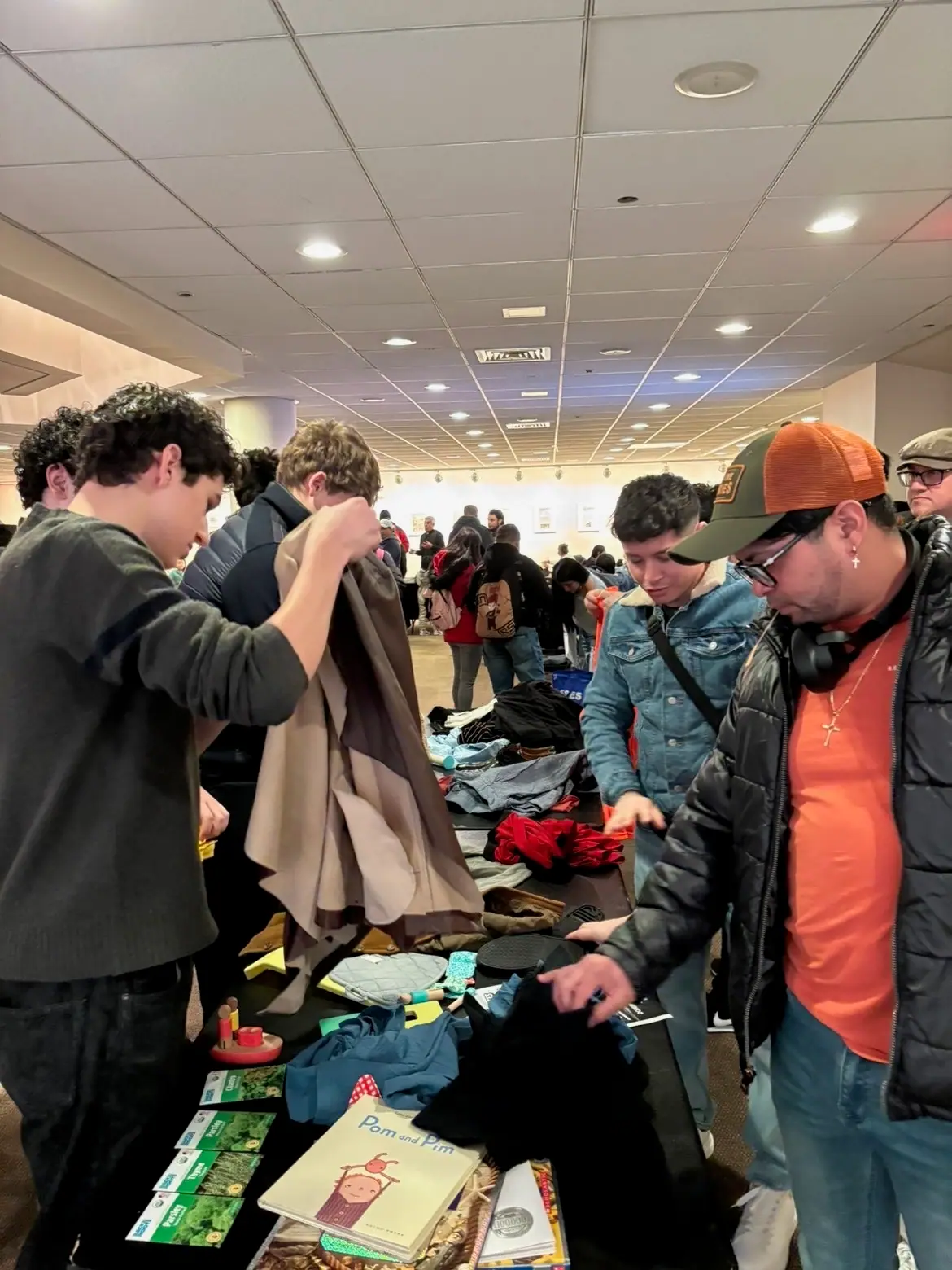 A crowd sorting through the donated-clothing tables.