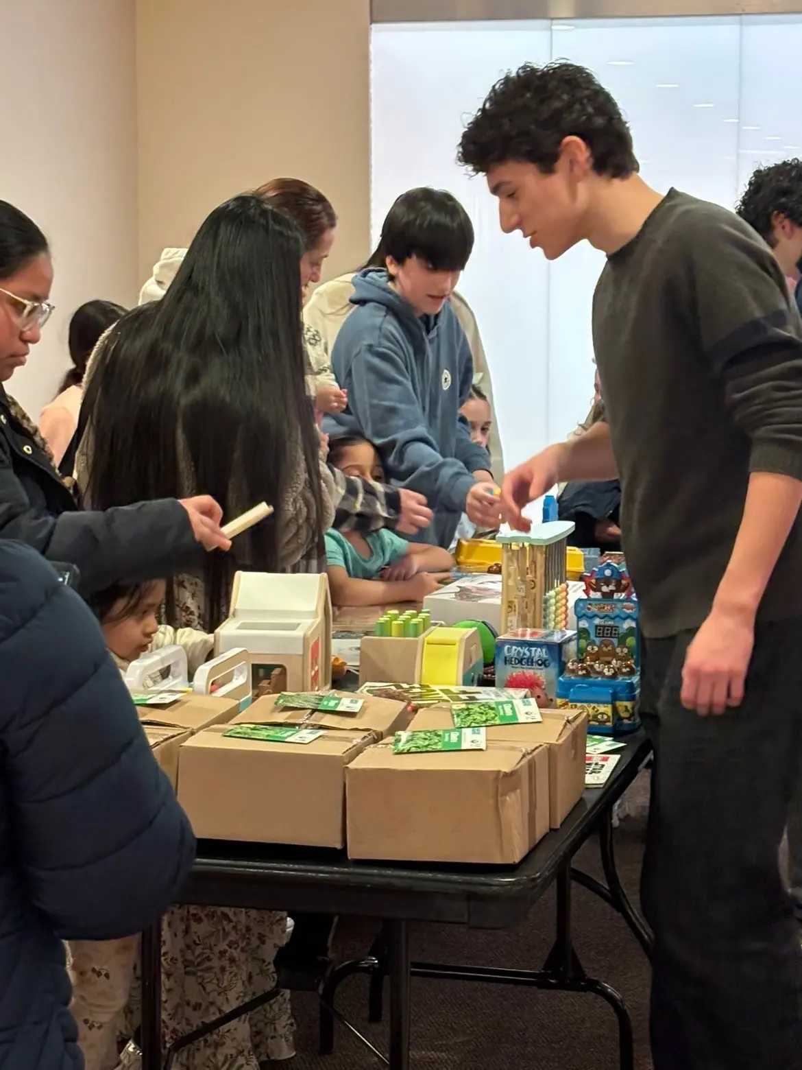 Families at the tables of MintBoxes and children's toys.