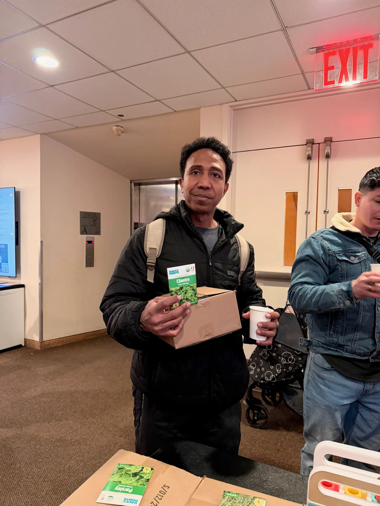 A guest holding his MintBox and a cilantro seed packet.