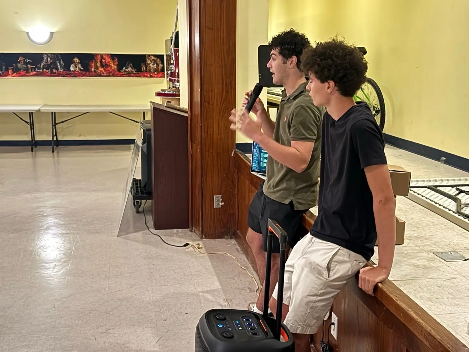 Two MintBox members presenting with a microphone and portable speaker so the whole room can hear.